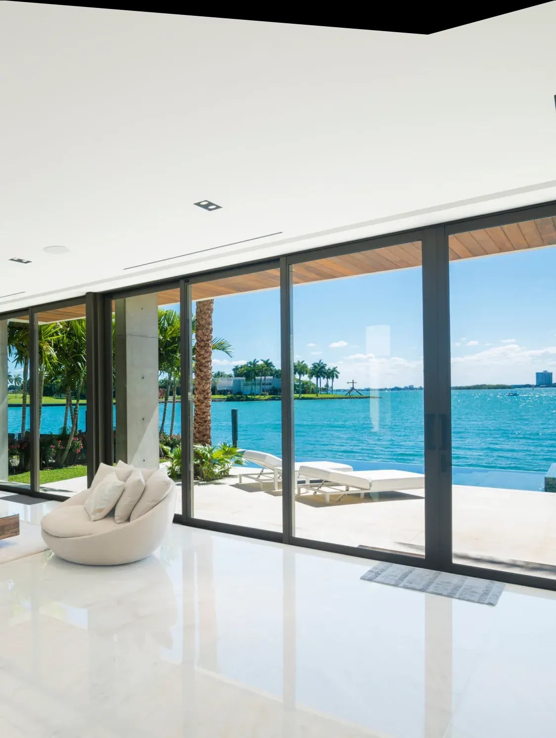 Waterfront living room opening onto the bay through impact sliding doors