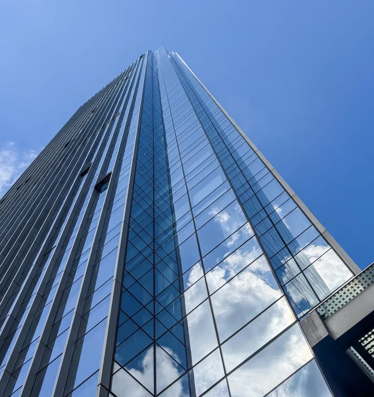 Glass facade of a modern skyscraper reflecting white light
