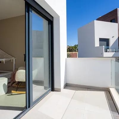 Sunny terrace with glass railing and sliding glass door